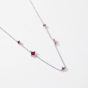 Elegante collana in argento S925 con zirconi rossi e pietre rosa su uno sfondo bianco puro