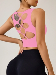 Détail du débardeur de sport rose avec design ajouré croisé dans le dos