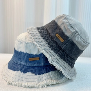 Gradient tie-dye denim bucket hats with frayed edges in blue and black colors