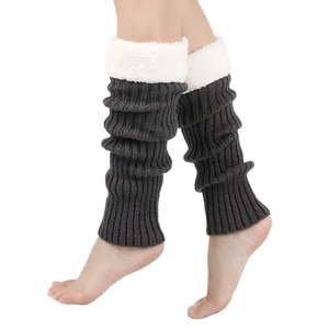 Detail of dark grey knit leg warmers featuring thick white faux fur lining and plush cuffs