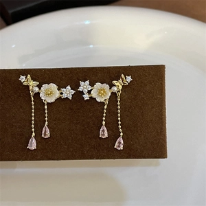 Detail of vintage gold floral earrings with pink crystal tassels and mother-of-pearl