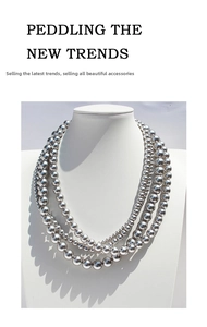 Multi-layered silver bead necklace featuring various sizes on a white mannequin display