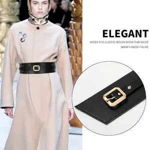 Women's elegant wide black corset belt with gold rectangle buckle on beige coat