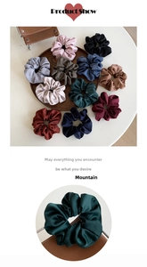 Detailed close-up of large ruffled scrunchies in various matte satin colors