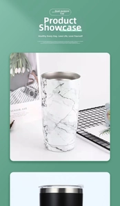 Detail of white marble and matte black dual-wall stainless steel insulated travel tumblers