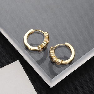 Detail of 18K gold-plated huggie earrings with three inlaid sparkling zircon stones