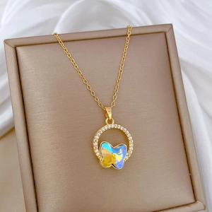 Macro detail of golden butterfly crystal pendant with colorful rhinestones in a beige jewelry box