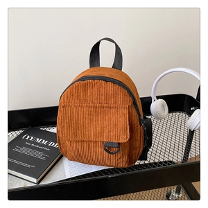 Detail of caramel corduroy backpack with D-ring buckle on a black metal trolley