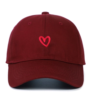Close-up of red heart embroidery on burgundy cotton baseball cap with twill texture