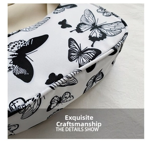 Close-up of the fine stitching and butterfly print detail on the twill fabric shoulder bag