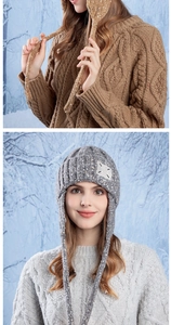 Detailed knit texture of a warm winter hat with earflaps and tassels on snowy background