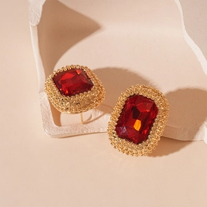 Macro detail of vintage Ankara red gemstone earrings with gold beaded edges