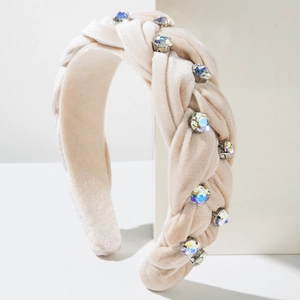 Close-up of champagne velvet braided headband with sparkling rhinestone embellishments