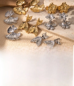 Detail of titanium steel earrings in ginkgo leaf, flower, and fishtail shapes in gold and silver
