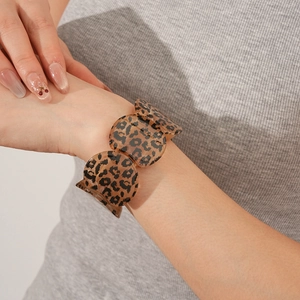 Detailed view of leopard print resin bracelet showing glossy texture on a sweater sleeve