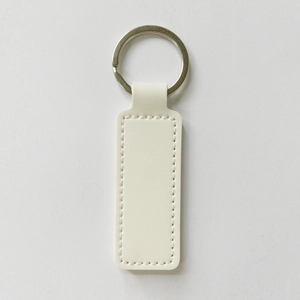 Close-up of white PU leather keychain with metal ring and detailed side stitching