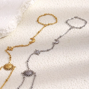 Détail de la chaîne de main céleste avec breloques soleil lune et étoile en or 18K