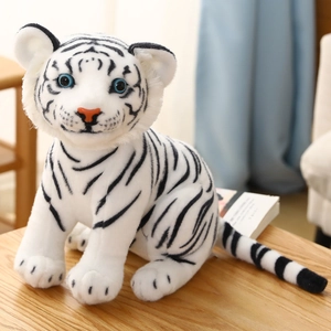 Detail van witte pluche tijger knuffel met zwarte strepen en blauwe ogen op houten tafel