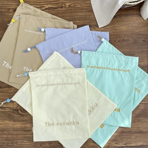 Close-up of drawstring organizers with embroidered quotes and adjustable stoppers