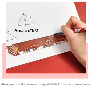 Close-up of a 15cm Christmas ruler and pen set being used to draw shapes on white paper