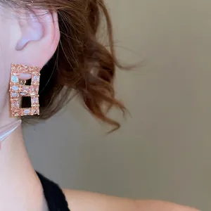18K rose gold plated hollow rectangle earrings with purple zircon crystals on model