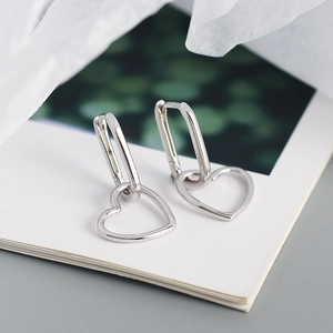 Macro detail of silver S925 geometric heart earrings with polished metal finish