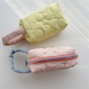 Macro detail of quilted flower makeup bags with zipper closure and soft handles