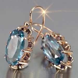 Elegantes pendientes de oro rosa con piedras ovaladas azul claro y engaste de garras