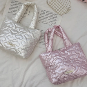 Dettaglio borse trapuntate a cuore in nylon bianco perla e rosa con fibbie in metallo
