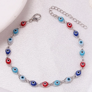 Detail of silver chain bracelet featuring red and blue evil eye charms with lobster clasp