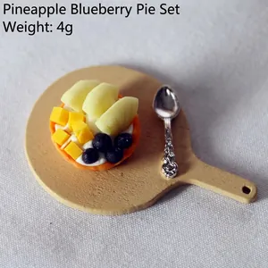Macro shot of dollhouse miniature blueberry pineapple pie with wooden tray and silver spoon