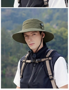 Detail of army green outdoor sun hat with wide brim and compass detail in nature