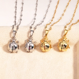 Detail of ladybug pendants in gold and silver finish with rhinestones on steel chains