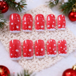 Christmas press-on nails set with red base, white dots and festive tree snowman designs