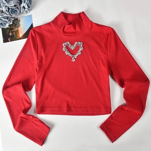 Close-up of red ribbed knit top featuring a sparkling rhinestone heart cutout design