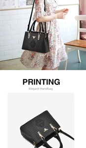 Detailed view of black leather handbag with embroidered patterns and golden metal hardware
