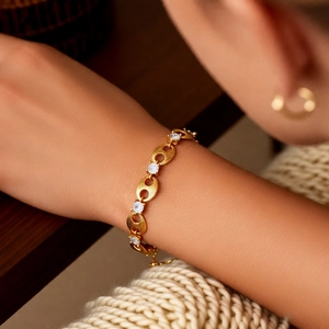 Detail of gold zircon pig nose chain bracelet worn on wrist with elegant lifestyle aesthetic