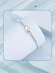 Detailed view of S925 sterling silver starry bracelet with a heart charm on blue background