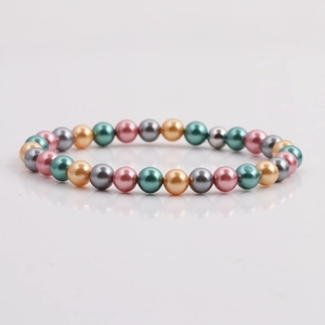 Bracciale di perle di conchiglia colorate con perle rosa, oro e grigio su fondo bianco