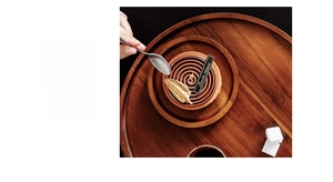 Top view of a round dark wood tray featuring natural grain texture and matte finish