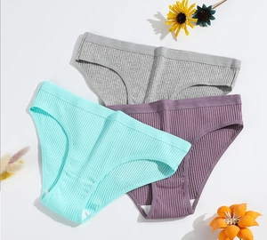 Détail de trois culottes en coton côtelé en gris, vert menthe et violet sur fond blanc