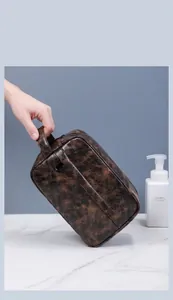Detailed close-up of brown vintage PU leather texture on a business toiletry bag