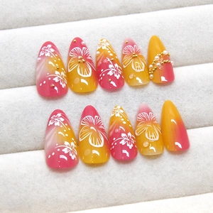 Pink and yellow ombre almond press-on nails with hibiscus flowers and pearls