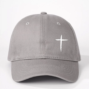 Dettaglio del cappellino da baseball grigio con trama del tessuto e ricamo a croce bianca