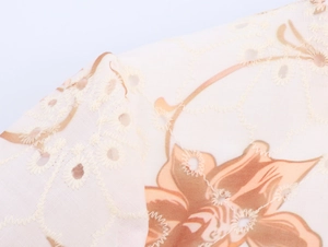 Dettaglio dell'abito boho con stampa floreale marrone e ricami traforati sulla trama
