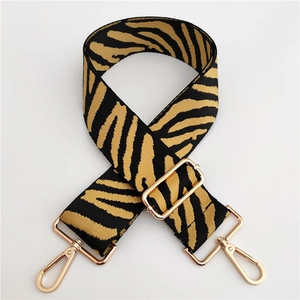 Close-up of zebra pattern wide strap with gold-tone metal lobster clasps and buckle