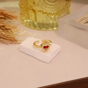 Detailed macro view of the gold heart crown ring with red gemstone on stone pedestal