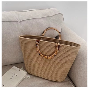 Large hand-woven tote bag with natural bamboo handles and spacious trapezoid design