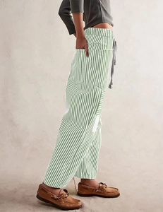 Detail of green and white vertical striped trousers with a grey drawstring waist