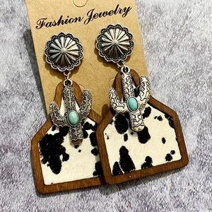 Western boho earrings with faux turquoise cactus and cowhide leather patterns on wood